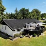 Wohnhaus mit Terrasse, Garten und Umgebung mit Bäumen.