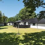 Wohnhaus mit Garten und Sonnenschirm unter Bäumen