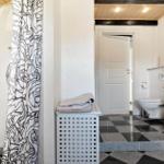 Badezimmer mit Dusche, Toilette und schwarz-weißem Boden