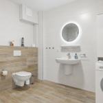 Badezimmer mit Toilette, Waschbecken und Waschmaschine