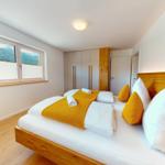 Schlafzimmer mit Bett, Fenster und Kleiderschrank