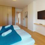 Schlafzimmer mit Doppelbett, Kleiderwand und Wandfernseher
