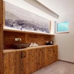 Holzpaneel-Wand mit Waschbecken, Kaffeemaschine und Wandbild