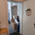 Eingangsbereich mit Schuhgarderobe, Willkommensschild und Kleiderschrank.