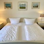 Bedroom with double bed, two nightstands, and lamps beside the bed.