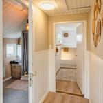 Hallway with two doors, one leads to a bathroom, the other to a bedroom.