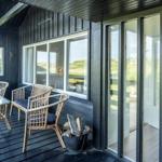 Patio with rattan furniture and view of green landscape.
