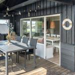 Terrace with table, chairs, and grill. Entrance into house with dining area.