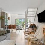 Living area with sofa, dining area, and staircase to upper level.