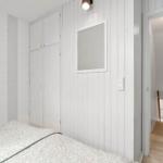 Bedroom with bed, closet, and wall art. Door leads to a hallway.