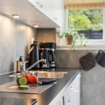 Kitchen with countertop, sink, and window with plant.