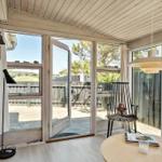 A room with large windows, a door to the outside area, and a round table.