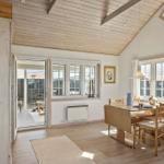 Dining room with wooden table, chairs, and windows. Attic with skylight and wooden ceiling.