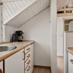 Kitchen with wooden surfaces, stainless steel sink, and window under gable roof.