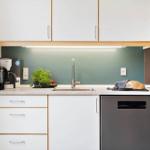Küche mit Arbeitsfläche, Spüle, Kaffeemaschine und Backofen.