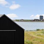 Ansicht vom Fenster auf Wasser und Hütten am Ufer