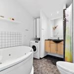 Bad mit Whirlpool, Waschmaschine und Holzschrank.