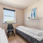 Zwei Betten, Holzwand, Spiegel, Tür zum Flur und Kleiderschrank.