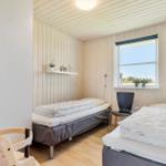 Eingangsbereich mit Holzboden, Spiegel, Garderobe und Treppe zur oberen Etage.