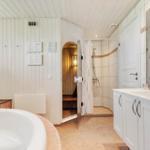 Sauna mit Holzwand, Sitzbank und Holzkanister