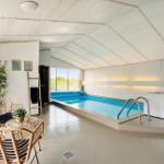 Innenpool mit Whirlpool und Sitzbereich unter weißem Dach