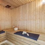 Badezimmer mit Dusche, Waschbecken und Toilette. Wandgestellte Handtuchhalter.