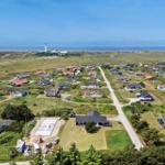 Aerial view of a coastal village with houses, roads, and nearby sea.