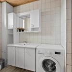 Badezimmer mit Toilette, Waschbecken und Dachfenster unter Holzdecke.