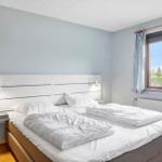 Schlafzimmer mit Doppelbett, Fenster und Holzboden.