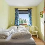 Zwei Einzelbetten, Fenster mit Blick auf Wald, Wandbild und Heizkörper.