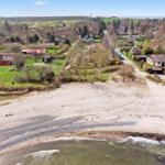 Haus mit rotem Dach neben Strand und See