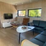 Ein Wohnzimmer mit einem blauen Sofa, einem weißen Tisch und Holzwänden.
