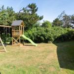 Hinterhof mit Holzspielplatz, Schaukel und Rutsche auf Rasenfläche.