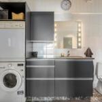 Badezimmer mit Waschmaschine, Spiegelschrank und Toilette.