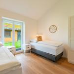 Zwei Betten, Kleiderschrank und Fenster mit Blick auf Garten