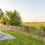 Terrasse mit Liegestühlen und Blick auf grünes Feld
