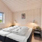 Bedroom with double bed, wood paneling, and window view of landscape.