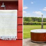 Outdoor shower with towel on red wood wall. Hot tub with wooden frame on terrace.