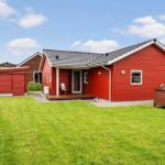 Red house with garden, terrace, and small annex. Background shows other houses.