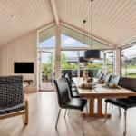 Dining area with wooden table, black chairs, and large window view.