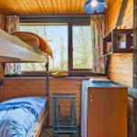 Zimmer mit Doppelstockbett, Fenster und Holzwand