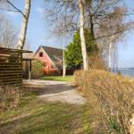 Haus mit Blick auf Wasser, gepflasterter Weg und Bäume