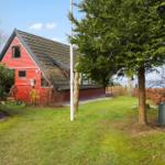 Rotes Haus mit Garten und Blick auf Wasser