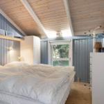 Bedroom with bed, wardrobe, and window. Wooden ceiling and blue walls.