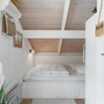 Bedroom with white bed, wooden ceiling, and door with sign.