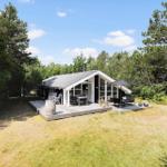 Modern cabin with terrace, garden, surrounded by trees.