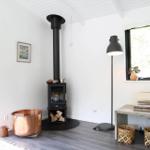 Ein Wohnzimmer mit Fenster, Fernseher und dekorativen Gegenständen auf Tischen.