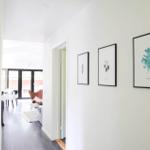 Badezimmer mit Badewanne, Handtuchständer und Poster an der Wand.
