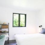 Durch das Fenster blickt man auf einen grünen Garten mit Bäumen und Sträuchern.