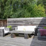 Holzterrasse mit Tisch und Sitzbank unter Dach